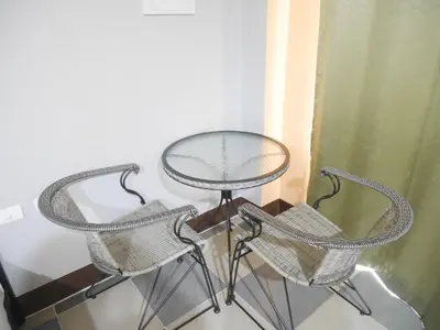 two chairs and a table and a table and chairs at Nasa Hotel in Phuket Town