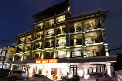a tall building with cars parked in front of it at Lub Sbuy House Hotel - SHA in Phuket Town