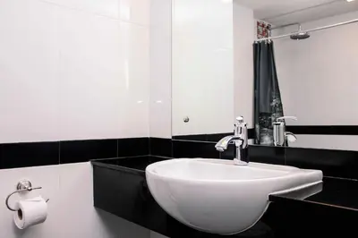 a bathroom with a white sink and a mirror at Lub Sbuy House Hotel - SHA in Phuket Town