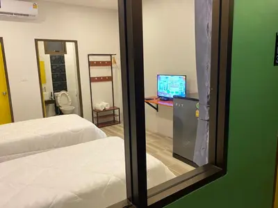 a reflection of a bedroom with a bed and a mirror at N&N HOUSE Laem Hin in Ban Laem Hin