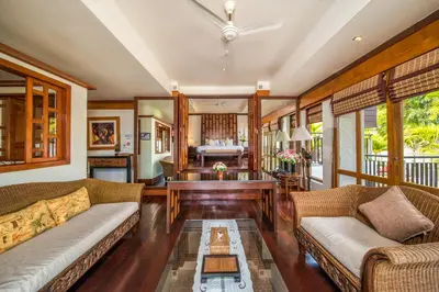 a living room with two couches and a table at Baan Yin Dee Boutique Resort Phuket - SHA Plus in Patong Beach