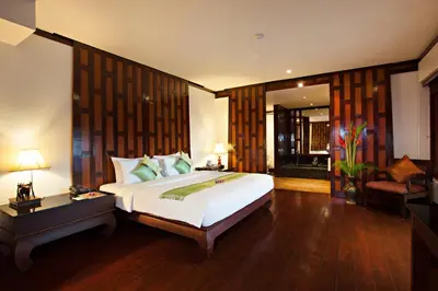 a bedroom with a large white bed in a room at Baan Yin Dee Boutique Resort Phuket - SHA Plus in Patong Beach