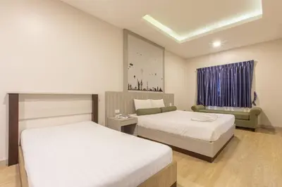 a hotel room with two beds and a couch at Mai Morn Resort SHA Plus in Phuket Town