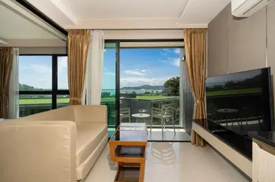 a living room with a couch and a large window at Panora sea view -modern facilities walk to beach in Surin Beach