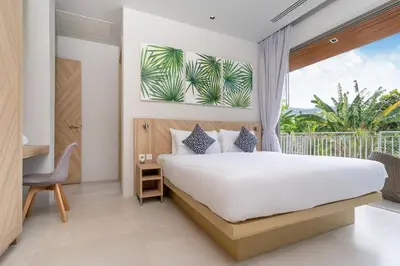 a bedroom with a bed and a large window at Himmapana Villas - Terraces - SHA Extra Plus in Kamala Beach
