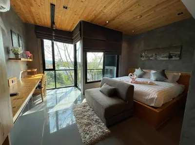 a bedroom with a bed and a chair and a desk at Relife The Windy by VillaCarte in Rawai Beach