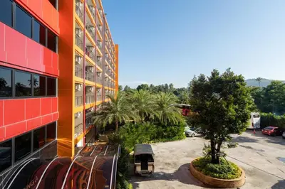 a balcony of a building with a tree and benches at Mai Khao Beach Condo by VillaCarte in Mai Khao Beach