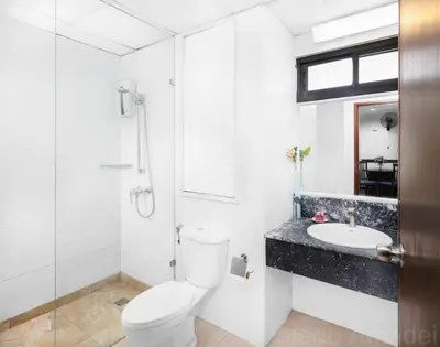 a white bathroom with a toilet and a sink at Patong Tower Sea View by PHR in Patong Beach