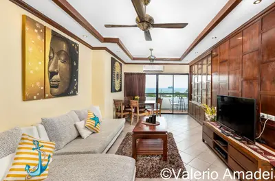 a living room with a couch and a tv at Patong Tower Sea View by PHR in Patong Beach