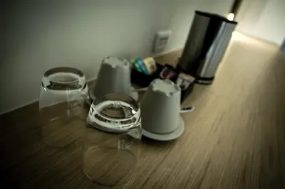 a table with two cups and a coffee maker on it at TIRAS Patong Beach Hotel in Patong Beach