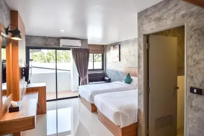a hotel room with two beds and a window at Dee Homestay in Ban Pa Khlok