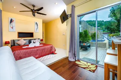 a bedroom with a bed and a large window at Dreambeach 2-villas in Panwa Beach
