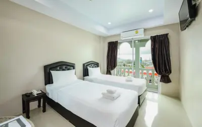 two beds in a room with a balcony at Tyler Cherngtalay in Ban Pak Lak