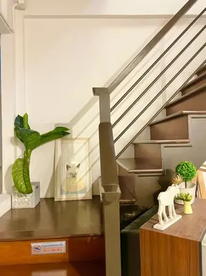 a room with a staircase with a table with a horse statue at Primego Boutique Hotel in Phuket Town