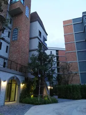 a building with a tree in front of it at Luxury Apartment at Title Residencies Naiyang Beach in Phuket Town