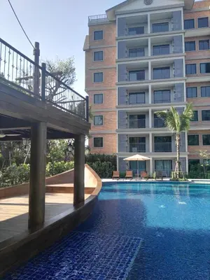 a swimming pool in front of a large building at The Apartment at The Title Residencies Naiyang Beach in Phuket Town