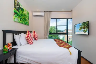 a bedroom with a white bed and a window at The Title Rawai Beach West Wing in Phuket Town