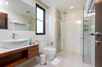 a bathroom with a toilet and a sink and a shower at The Title Rawai Beach West Wing in Phuket Town