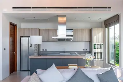 a living room with a couch and a kitchen at Botanica Bangtao Beach Villa in Phuket Town