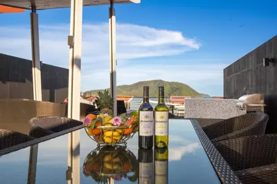 two bottles of wine on a table with a bowl of fruit at Fantastic SeaView 4br Private Pool Villa in Rawai Beach