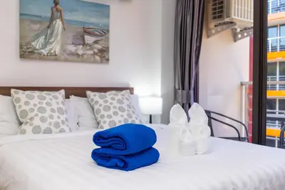 a bed with blue towels sitting on top of it at LUMA Condo 1BR Open View NBC Nai Harn in Rawai Beach
