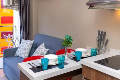 a living room with a table and a blue couch at LUMA Condo 1BR Open View NBC Nai Harn in Rawai Beach