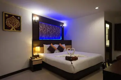 a bedroom with a large bed with a blue light at Patong Mansion - SHA Certified in Patong Beach