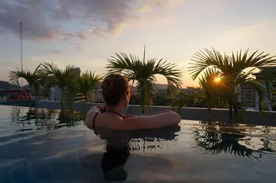 a person sitting in a pool on top of a building at Patong Mansion - SHA Certified in Patong Beach