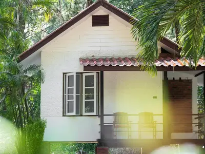 a small house with chairs on the porch at Sand Beach Bungalow in Klong Muang Beach