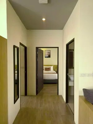 a room with a bedroom with a bed and mirrors at Charcoal Panwa Beach Phuket in Ban Tha Khreng