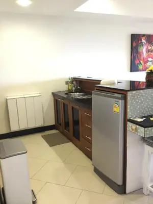 a kitchen with a stainless steel refrigerator and cabinets at Kata Beach Aspasia Boutique Apartment in Kata Beach