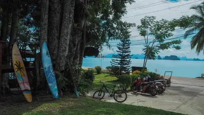 a group of bikes parked next to a tree with a surfboard at Holiday Resort - SHA Plus in Ko Yao Noi