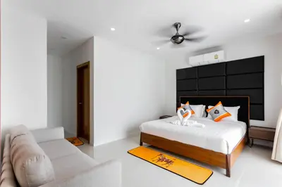a bedroom with a bed and a couch at Hideaway Lake Villas By Cozy Lake in Bang Tao Beach