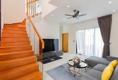 a living room with a couch and a staircase at Hideaway Lake Villas By Cozy Lake in Bang Tao Beach