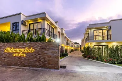 a house with a brick retaining wall in front of it at Hideaway Lake Villas By Cozy Lake in Bang Tao Beach