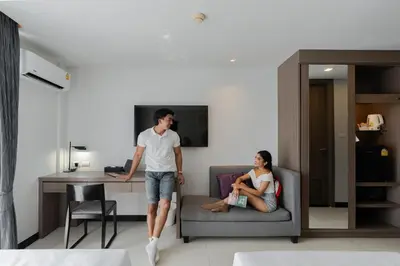 a man and a woman standing in a living room at Citrus Patong Hotel by Compass Hospitality in Patong Beach