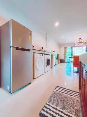 a kitchen with a refrigerator and a washer and dryer at The Nakara Town in Ban Rangeng