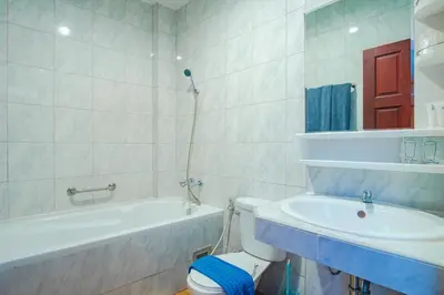 a bathroom with a tub and a toilet and a sink at Art Mansion Patong Hotel in Patong Beach