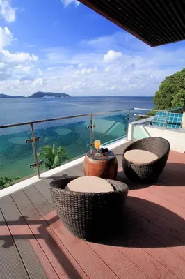a balcony with two chairs and a view of the ocean at Zenmaya Oceanfront Phuket, Trademark Collection by Wyndham in Patong Beach