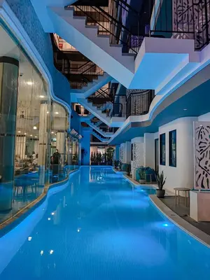 a large swimming pool in a building with blue floors at Poolrada Boutique Hotel - SHA Plus in Thalang