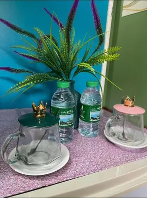 a table with two bottles of water and a potted plant at San Antonio Beach Guesthouse & Restaurant in Kata Beach