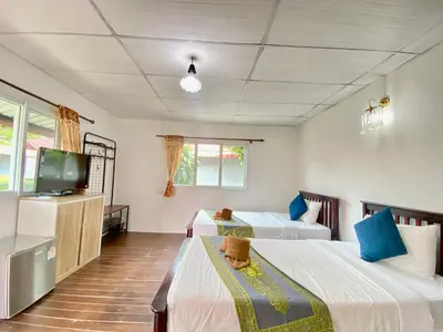 a room with two beds and a flat screen tv at Phi Phi Ba Kao Bay Resort in Phi Phi Don