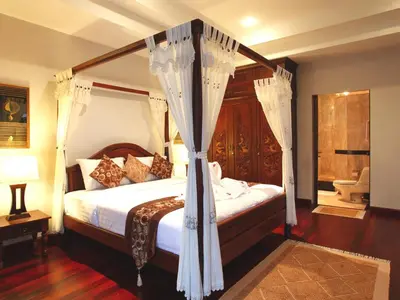 a bedroom with a canopy bed with curtains at Kata Sea View Villas in Kata Beach