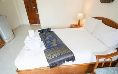 a bedroom with a bed with a blanket on it at Palmview Resort in Patong Beach