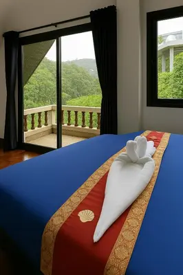 a bed with a towel on it with a window at Beverly Hills Villa Patong in Patong Beach