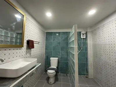 a bathroom with a sink and a toilet and a shower at Inn Dulgence in Patong Beach