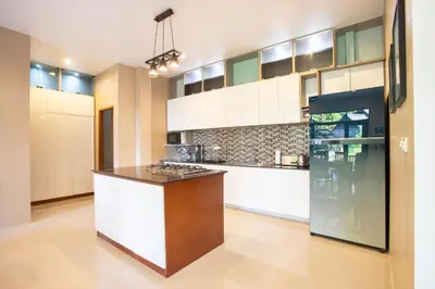 a kitchen with white cabinets and a black counter top at Heavenly Villas in Patong Beach