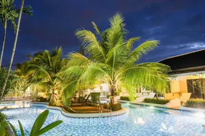 a swimming pool with palm trees in a resort at Tuana Hotels Brook Pool Access in Chalong