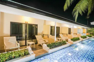 a hotel patio with chairs and a swimming pool at Tuana Hotels Brook Pool Access in Chalong