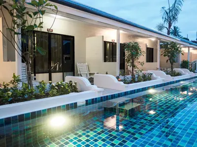 a hotel swimming pool with white chairs and a resort at Tuana Hotels Brook Pool Access in Chalong